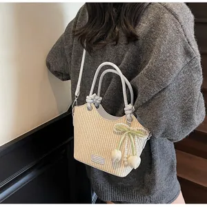 Detalle de bolso saco de paja con lazo de terciopelo verde, perlas y tulipanes