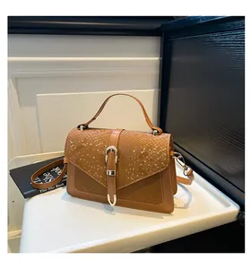 Detailed view of the brown snakeskin embossed leather texture and gold buckle closure