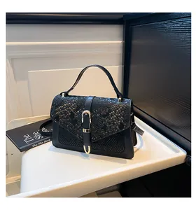 Detailed view of snake-embossed leather flap with elegant golden horse-bit buckle closure