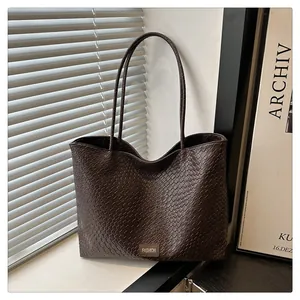 Détail du sac cabas marron à texture tressée et écusson en cuir Fashion élégant