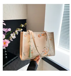 Detail of satin tote bag with persimmon embroidery and green decorative tassel