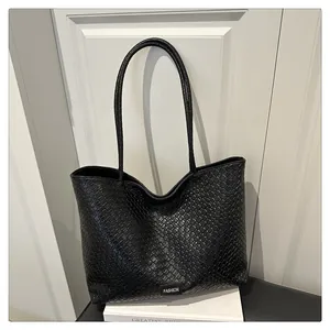 Détail de la texture tressée noire et du logo Fashion sur le sac cabas élégant à main