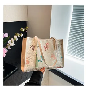 Detail of Chinese style tote bag with goldfish embroidery and green tassel ornament
