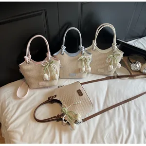 Detalle de bolsos bombonera de paja con etiquetas de cuero y colgantes florales