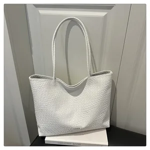 Gros plan sur la texture tressée blanche et l'étiquette mode du grand sac cabas