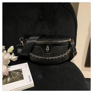 Detail of black crossbody chest bag with 3D skull embossing and metallic skull logo