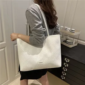 Sac fourre-tout tressé blanc pour femmes avec texture tissée et étiquette, idéal pour travailler