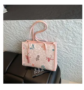 Close-up of pink oriental tote bag with traditional embroidery and silk tassel detail