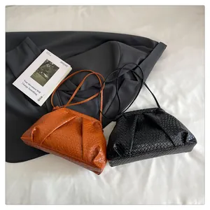 Detail of woven texture shell bags in orange and black with leather shoulder straps