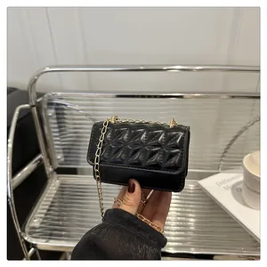 Close-up of black quilted leather mini bag with elegant gold chain strap detail