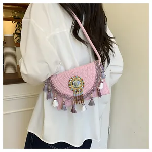 Dettaglio della borsa bohémien rosa tessuta a mano con perline e lunghe frange