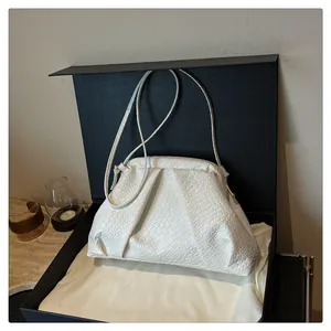Detailed woven texture of a white shell handbag presented in a luxury gift box