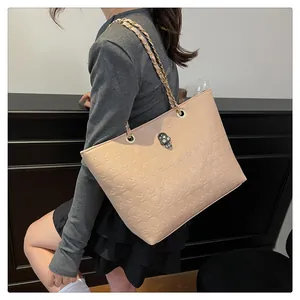 Détail du sac cabas beige avec motif tête de mort en relief et finitions métalliques