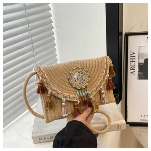 Dettaglio della borsa di paglia bohémien con nappe colorate e ricami etnici