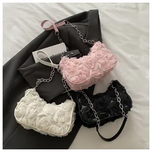 Détail des petits sacs carrés à fleurs en rose, crème et noir avec chaîne argentée