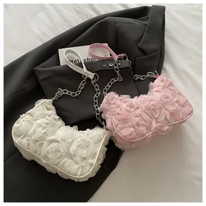 Détail de sacs bandoulière en organza floral avec roses 3D en blanc et rose