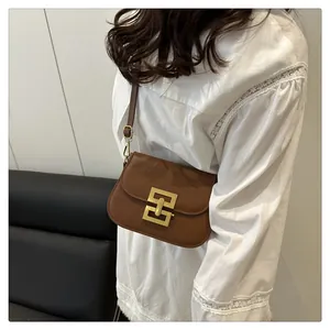 Detailansicht der braunen Umhängetasche aus Leder mit goldenem Metallverschluss für Damen