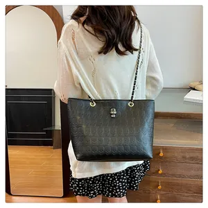Détail d'un sac cabas en cuir noir avec motifs têtes de mort et fermoir argenté chic