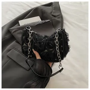 Détail du sac sous l'aisselle noir avec fleurs de rose en mousseline 3D et chaîne argentée