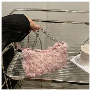 Détail de la texture florale en mousseline 3D et chaîne argentée sur un sac rose