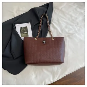 Détail du sac cabas marron foncé avec embossage tête de mort et fermoir métallique