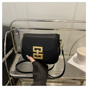 Detailaufnahme der schwarzen matten Umhängetasche aus Leder mit goldenem Metallverschluss