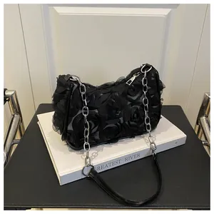 Détail du tissu en dentelle fleurie 3D et bandoulière en chaîne sur sac à bandoulière noir