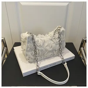 Détail d'un sac blanc avec roses en résille 3D et bandoulière chaîne argentée