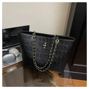Détail du sac cabas noir avec motif tête de mort en relief et logo tête de mort en métal