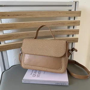 Close-up of brown textured weaving and smooth faux leather on contrast crossbody bag