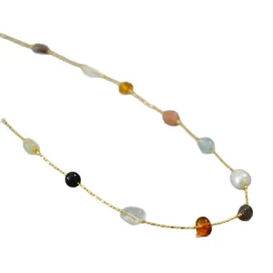 Golden chain necklace featuring irregular pearls and colorful crystal beads on white background