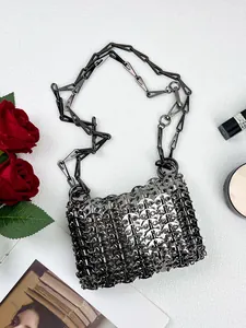Close-up of handmade silver sequin bag with metal chain strap and luxury accessories