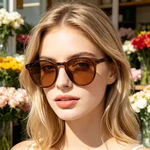 Fashionable round frame sunglasses in tea color on a female model with a stylish floral backdrop