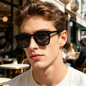 Lunettes de soleil homme à monture carrée noire portées par un mannequin en terrasse
