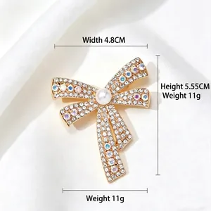 Elegant bow brooch in gold finish with diamonds and pearls, 4.8cm width and 5.55cm height