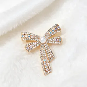 Macro shot of bowknot brooch with white rhinestones and a central faux pearl detail