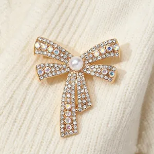 Elegant bow brooch with sparkling crystals and a central pearl on a knit sweater