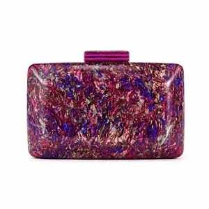 Macro detail of luxury acrylic evening clutch featuring purple marble swirl and gold hardware