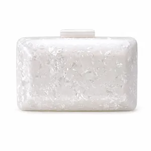 Detailed view of the white acrylic shell clutch with crushed pearl texture and clasp