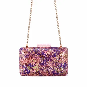 Close-up of hard shell clutch bag featuring purple and gold abstract resin textures