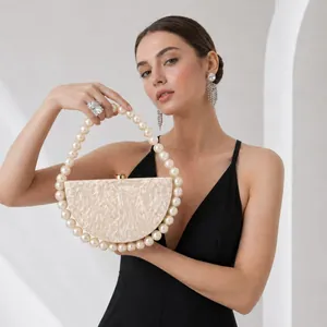 Pearlescent ivory acrylic clutch bag with round pearl handle and gold clasp closure