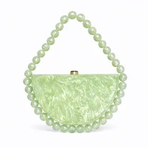 Detail of light green marble acrylic evening bag with beaded faux pearl handle and gold clasp