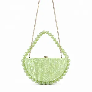 Detail of light green pearlescent acrylic bag with large emerald beads and gold chain