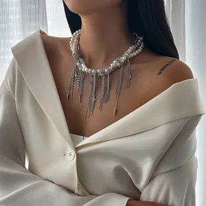 Détail du collier de perles multicouches et chaîne argentée avec glands et étoiles