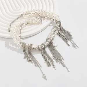 Détail du collier multicouche en perles et chaîne argentée avec breloques lune