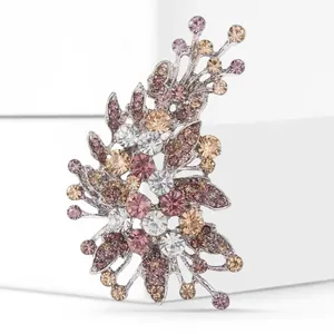 Macro shot of silver alloy brooch with multicolored rhinestones on a white pedestal