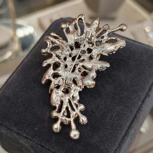 Detailed back view of irregular glass brooch with gold plating and safety pin