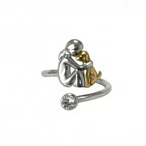 Close-up of dual-tone open ring featuring a girl hugging a dog with a sparkling crystal