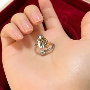 Artistic two-tone hug ring in stainless steel with a sparkling zircon accent