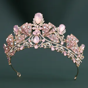 Detail of pink crystal teardrop stones and small diamonds on a gold bridal crown